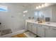 Bathroom featuring a walk-in shower, double sinks, white cabinets, and wood-look flooring at 1000 E Sunset Rd, Henderson, NV 89011