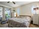 Bedroom with sliding glass doors to backyard patio, neutral colors, and ceiling fan at 1000 E Sunset Rd, Henderson, NV 89011