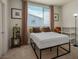 Clean bedroom with large window, a black metal bed frame, overhead lighting, and neutral carpet at 1000 E Sunset Rd, Henderson, NV 89011