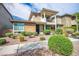 Inviting front view of a modern home with a unique balcony feature and desert-friendly landscaping at 1000 E Sunset Rd, Henderson, NV 89011