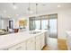 Large island with quartz counters, sink, and dishwasher adjacent to sliding glass patio doors at 1000 E Sunset Rd, Henderson, NV 89011