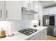 Close up of modern gas stovetop and stainless steel vent hood in a bright white kitchen at 1000 E Sunset Rd, Henderson, NV 89011