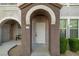 Inviting front entryway with arched doorway, secure gate, and manicured shrubs at 10001 Peace Way # 2228, Las Vegas, NV 89147