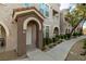 Townhome front entrance with neutral paint, arched porch, and manicured landscaping at 10001 Peace Way # 2228, Las Vegas, NV 89147