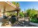 Spacious covered patio with ceiling fan, barbecue grill, and lush backyard landscaping at 1048 Painted Daisy Ave, Henderson, NV 89074