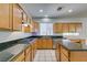 Spacious kitchen features wooden cabinets, granite countertops, tile flooring, and stainless steel appliances at 1048 Painted Daisy Ave, Henderson, NV 89074