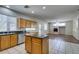 Spacious kitchen features wooden cabinets, granite countertops, tile flooring, and center island at 1048 Painted Daisy Ave, Henderson, NV 89074