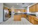 Spacious kitchen features wooden cabinets, granite countertops, tile flooring, and stainless steel appliances at 1048 Painted Daisy Ave, Henderson, NV 89074