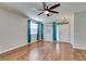 Bright living room with wood floors, a ceiling fan, and large windows with coverings at 1048 Painted Daisy Ave, Henderson, NV 89074