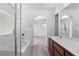Bright bathroom with double sink vanity, a shower-tub combination and an archway to the carpeted bedroom beyond at 10713 Noble Mesa Ave, Las Vegas, NV 89166