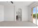 A bright, open bedroom boasts an ensuite bathroom and a balcony with a view of blue skies and green trees at 10713 Noble Mesa Ave, Las Vegas, NV 89166