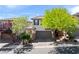 Exterior of a two story home with a two car garage and lush landscaping at 10713 Noble Mesa Ave, Las Vegas, NV 89166