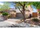 Attractive two-story home with a brick driveway, two-car garage, and lush trees in a residential neighborhood at 10713 Noble Mesa Ave, Las Vegas, NV 89166