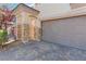 Close-up of a home's two-car garage with brick accents and a brick driveway at 10713 Noble Mesa Ave, Las Vegas, NV 89166