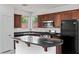 Modern kitchen featuring stainless steel appliances, granite countertops, and dark wood cabinets at 10713 Noble Mesa Ave, Las Vegas, NV 89166