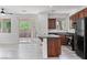 Modern kitchen with stainless steel appliances, dark countertops, an island, and sliding door access to the patio at 10713 Noble Mesa Ave, Las Vegas, NV 89166