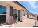 Cozy outdoor patio featuring concrete floors, a sliding glass door and brown shutters at 10713 Noble Mesa Ave, Las Vegas, NV 89166