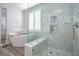Glass shower, marble walls and floors and soaking tub in a modern bathroom at 1125 Via Canale Dr, Henderson, NV 89011