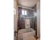 Modern bathroom with a glass-enclosed tub-shower combo and sleek gray tiling at 1125 Via Canale Dr, Henderson, NV 89011