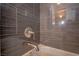 Close-up of the modern tub-shower combo with sleek gray tiling and chrome fixtures at 1125 Via Canale Dr, Henderson, NV 89011