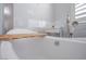 Modern bathtub with a wooden board and bath accessories on a rolling cart at 1125 Via Canale Dr, Henderson, NV 89011