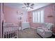 Charming pink Bedroom with crib, dresser, rocker, and decor, creating a sweet, welcoming space at 1125 Via Canale Dr, Henderson, NV 89011