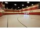 Spacious indoor gymnasium with basketball hoops, red and beige walls, and ample lighting for active recreation at 1125 Via Canale Dr, Henderson, NV 89011