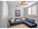 Cozy seating area with a blue sectional couch, fan, and modern decor at 1125 Via Canale Dr, Henderson, NV 89011