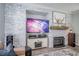 Living area with a shiplap accent wall including a fireplace, a console with electronics, and an adjacent piece of art at 1125 Via Canale Dr, Henderson, NV 89011