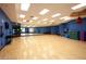 Bright and airy fitness studio with hardwood floors, blue walls, mirrors, and exercise equipment at 1125 Via Canale Dr, Henderson, NV 89011