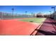 Well-maintained outdoor tennis court with a red and green surface, ready for a competitive match at 1125 Via Canale Dr, Henderson, NV 89011