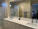 Modern bathroom featuring double sinks, sleek cabinets, a large mirror, and a walk-in shower at 11257 Rainbow Peak Ave # 201, Las Vegas, NV 89135