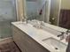 Bright bathroom featuring double sinks, modern cabinetry, and a glass-enclosed shower at 11257 Rainbow Peak Ave # 201, Las Vegas, NV 89135