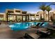 Stunning pool with many chairs in a modern backyard setting for enjoying warm evenings at 11257 Rainbow Peak Ave # 201, Las Vegas, NV 89135