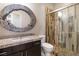 Well-lit bathroom features a vanity with granite countertops and a glass-enclosed shower with decorative tile at 12254 Cape Cortez Ct, Las Vegas, NV 89138