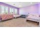 Spacious bedroom with two baby beds, a soft blue loveseat, shuttered windows and a chandelier at 12254 Cape Cortez Ct, Las Vegas, NV 89138