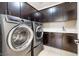 Modern laundry room with dark cabinetry, washer and dryer at 12254 Cape Cortez Ct, Las Vegas, NV 89138