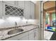 Wet bar features granite countertops, wine rack, modern fixtures, and outdoor access at 12254 Cape Cortez Ct, Las Vegas, NV 89138
