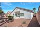 Backyard view with desert landscaping, a small covered patio, and block wall fencing at 129 Sapodilla Ln, Las Vegas, NV 89144