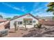 View of home's backyard with desert landscaping and covered patio in a bright sunny environment at 129 Sapodilla Ln, Las Vegas, NV 89144