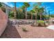 Spacious backyard with rock landscaping and mature palm trees for privacy at 129 Sapodilla Ln, Las Vegas, NV 89144