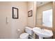 Half bath with a pedestal sink, toilet, and decorative wall art at 129 Sapodilla Ln, Las Vegas, NV 89144