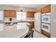 Bright kitchen with tile counters, white appliances, and wooden cabinetry at 129 Sapodilla Ln, Las Vegas, NV 89144