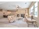 Spacious living room with a fireplace, large windows, and comfortable seating with neutral color palette at 129 Sapodilla Ln, Las Vegas, NV 89144