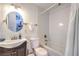 This well-lit bathroom features a shower over tub and a circular mirror over the sink vanity at 1508 Dorothy Ave # 4, Las Vegas, NV 89119