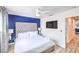Spacious bedroom with white and blue accents, a ceiling fan, and a door leading to a hallway at 1508 Dorothy Ave # 4, Las Vegas, NV 89119