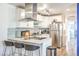 White kitchen features stainless steel appliances, a mosaic backsplash, and a breakfast bar with barstool seating at 1508 Dorothy Ave # 4, Las Vegas, NV 89119