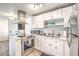 Renovated kitchen with stainless appliances, white cabinets, breakfast bar seating and decorative tile flooring at 1508 Dorothy Ave # 4, Las Vegas, NV 89119