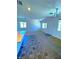 A large living room is decorated with a decorative chandelier, lots of windows, and decorative tile and carpet flooring at 20 Barbara Ln # 47, Las Vegas, NV 89183