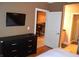 Cozy bedroom featuring a dresser with a TV and an open doorway to the kitchen and bathroom at 220 E Flamingo Rd # 104, Las Vegas, NV 89169